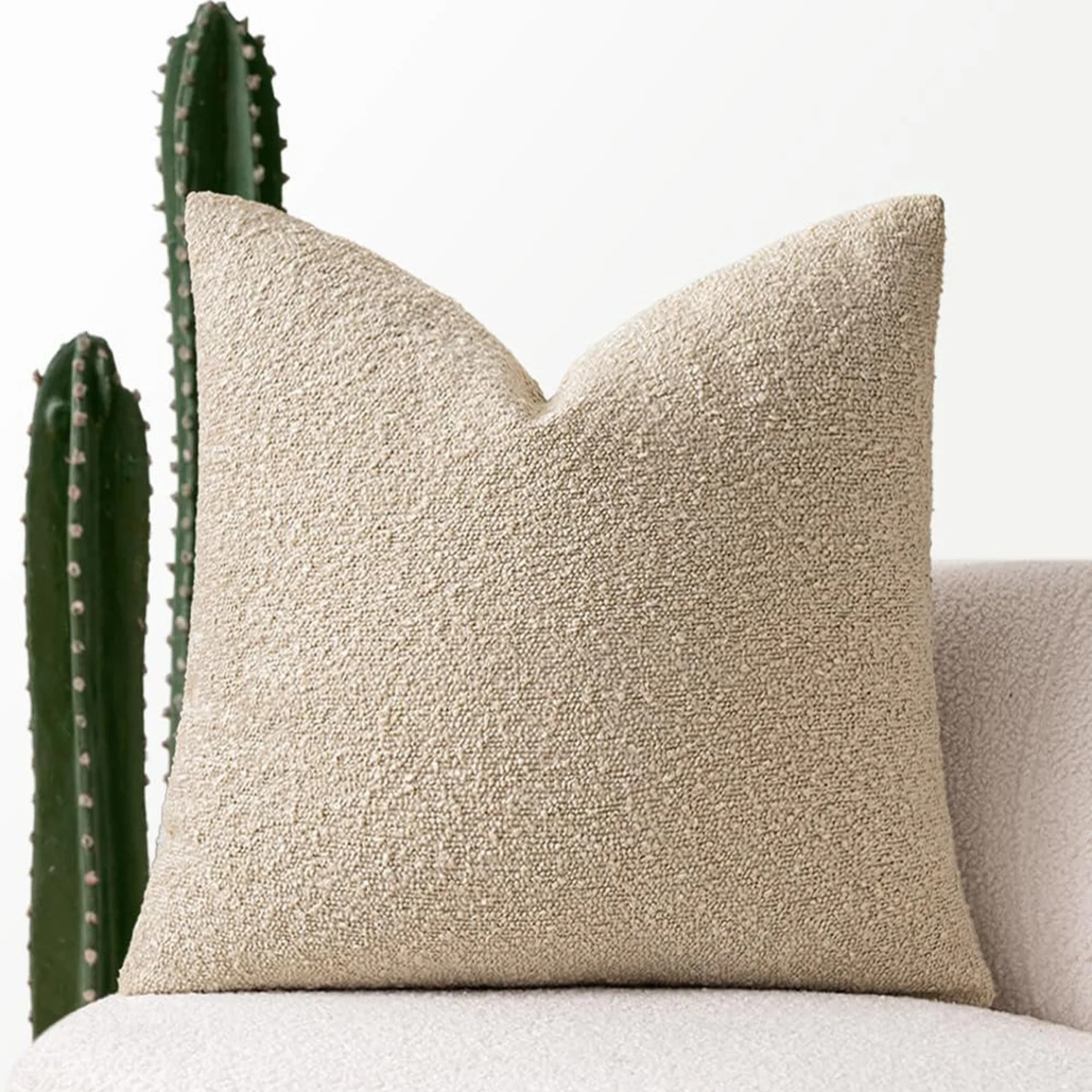 Sierkussenhoes van bouclé polyester gecombineerd met andere kussens op bed