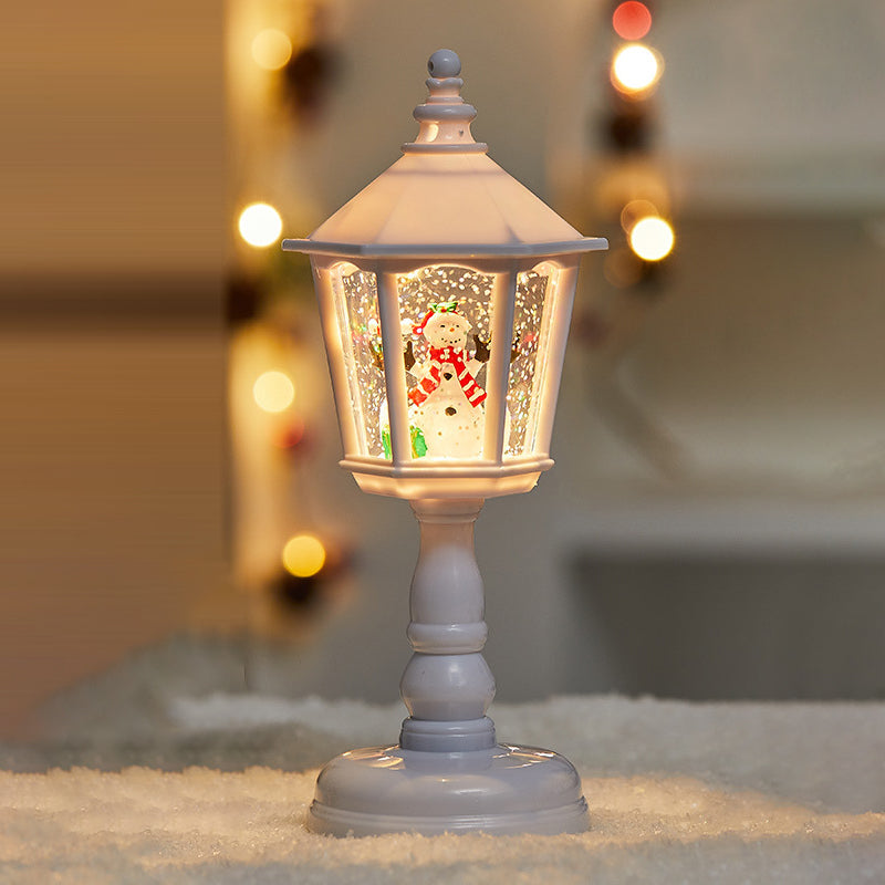 Huisvormige tafellamp naast kerstdecoratie