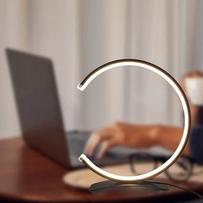 C-vormige lamp naast een bed als praktische nachtlamp