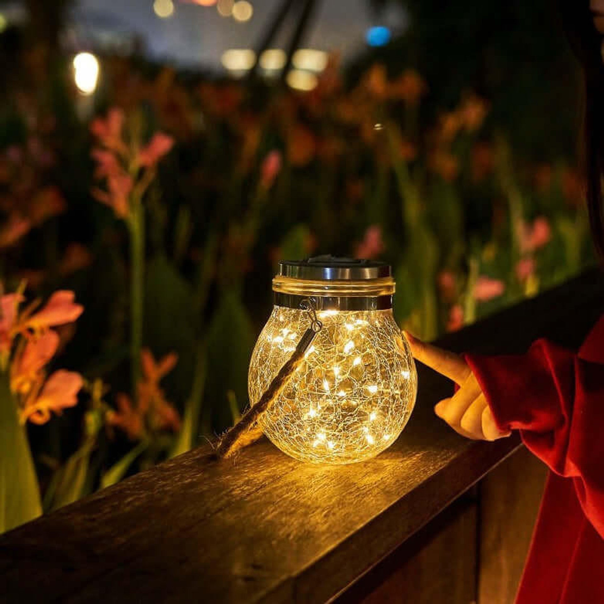 Sfeervolle solar tuinlamp van glas langs een tuinpad