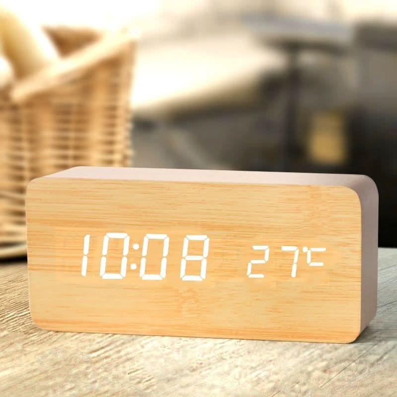 digitale led wekker met houtlook op een nachtkastje