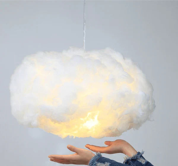wolkenlamp met zachte gloed naast een bed