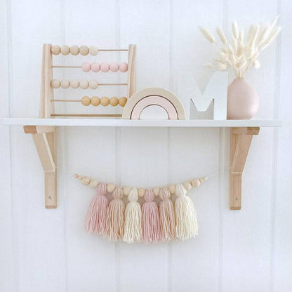 Houten kralenslinger hangend aan de wand in een babykamer