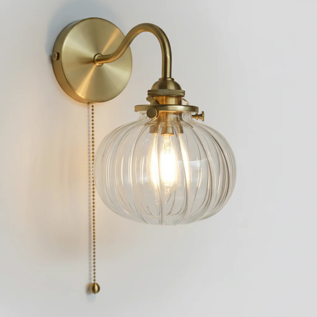 Zijaanzicht van de wandlamp van glas en goudkleurig metaal