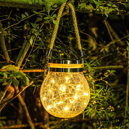 Glazen tuinlamp op zonne-energie staand in de tuin