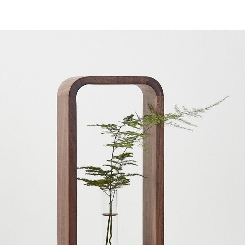 Stekjes in glazen buizen geplaatst in een strak houten frame