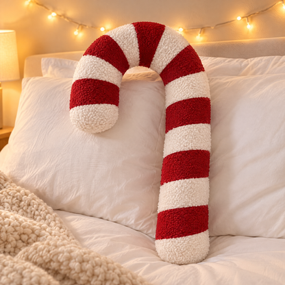 Pluche kerstkussen in zuurstokvorm op een sofa